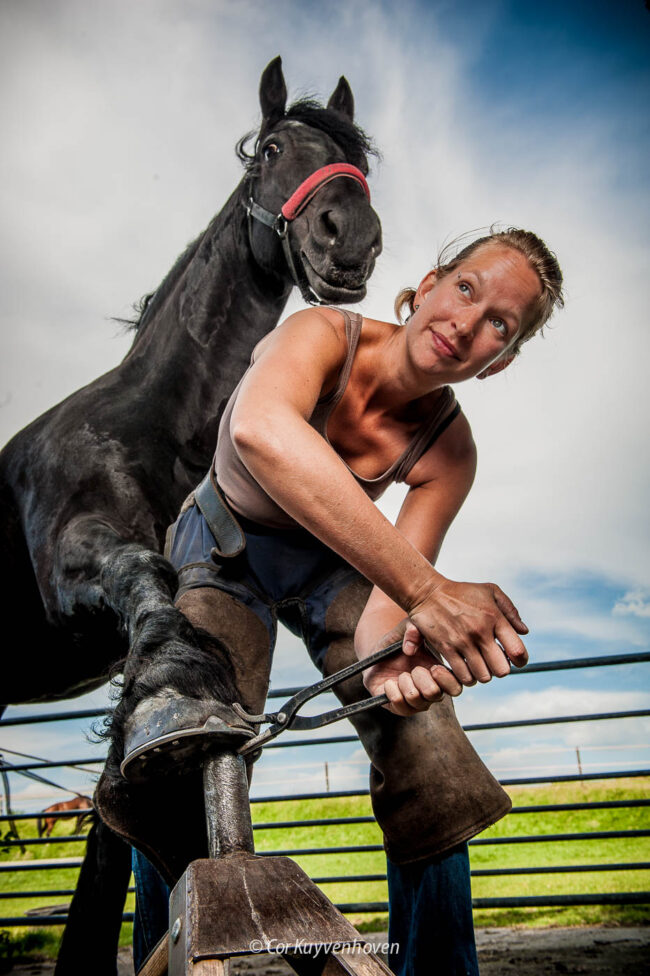 Hoefsmid-vrouw aan het werk met paard
