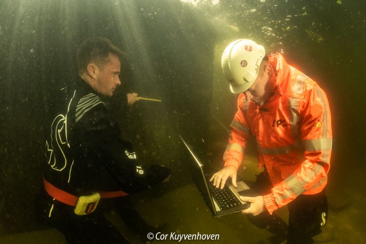 De mensen van RPS zijn onderwater aan het werk om een kade muur te inspecteren.
