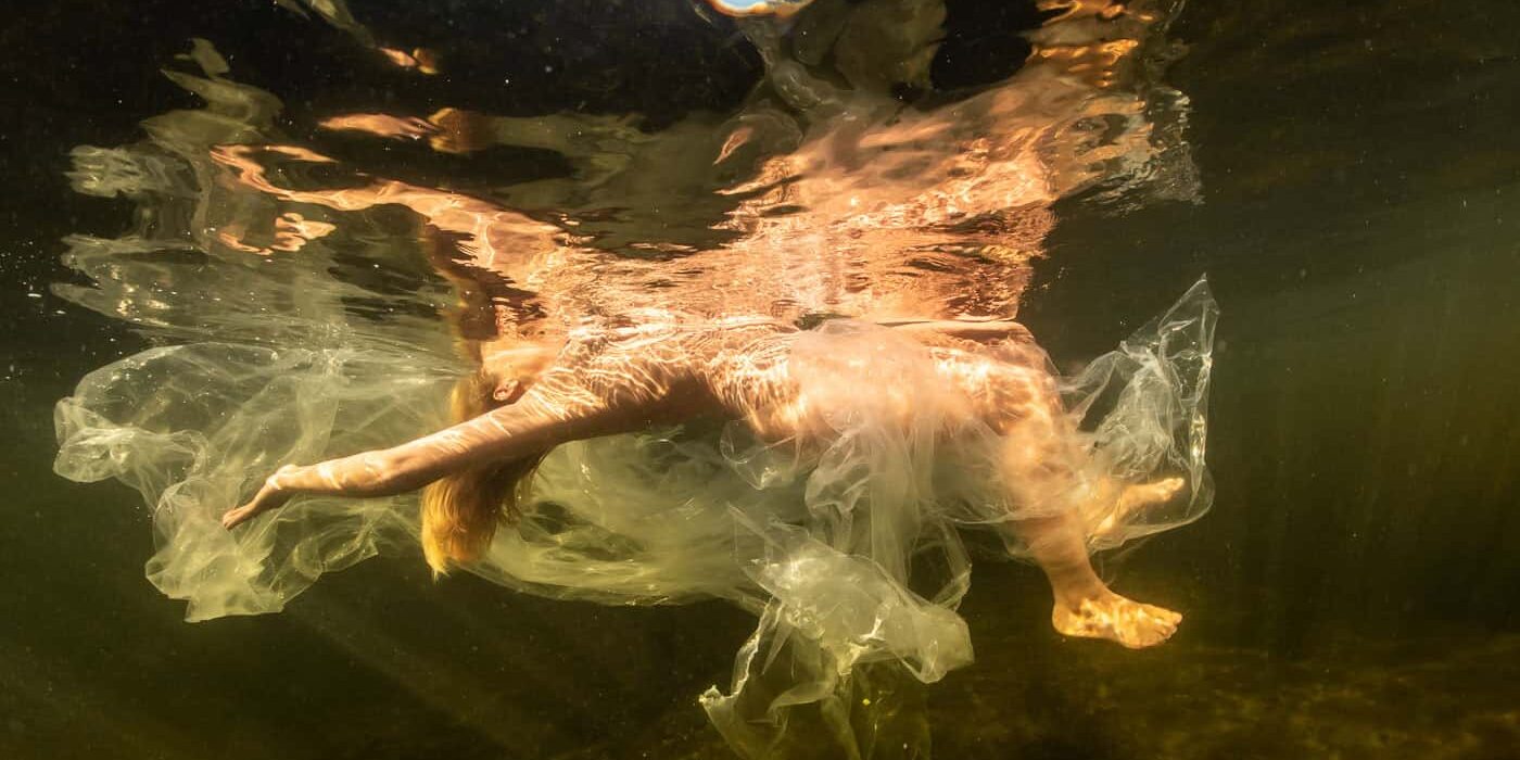Naakte vrouw onderwater in plastic