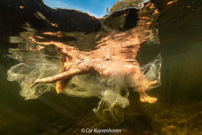 Naakte vrouw onderwater in plastic