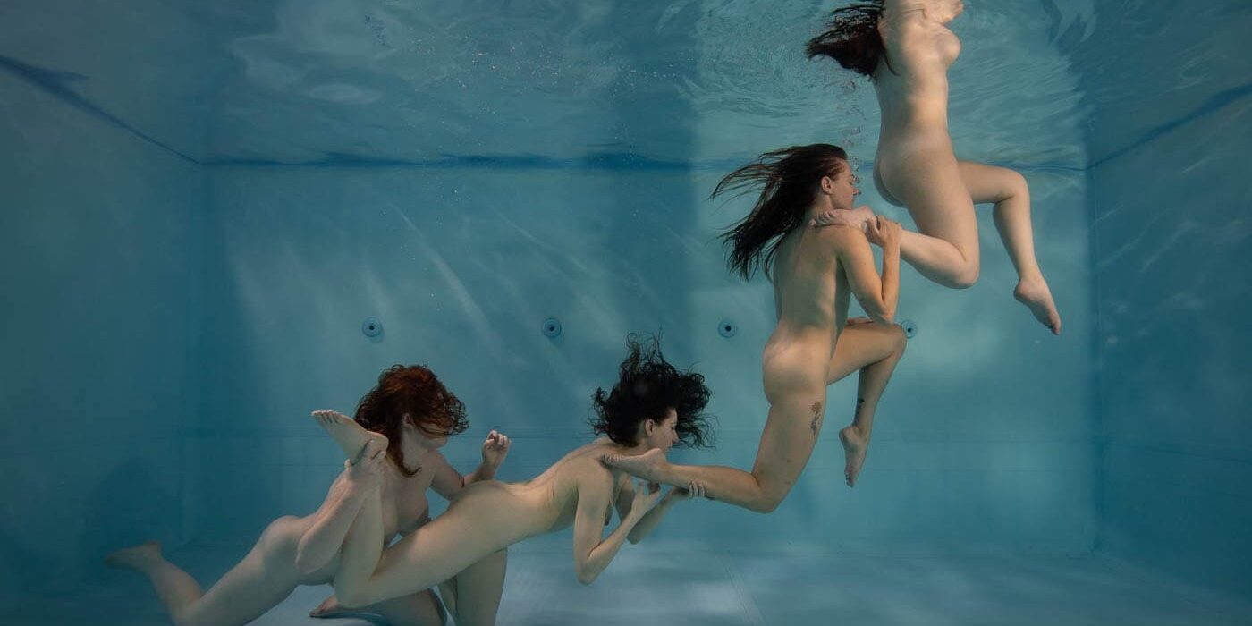 Nude vrouwen onder water, creatief kunstwerk, menselijke keten, onderwaterfotografie, expressief, artistiek en esthetisch, diversiteit en kwetsbaarheid.
