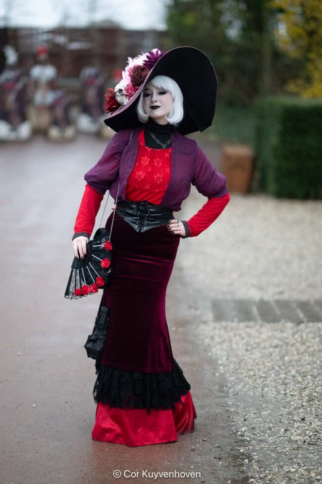 Unieke vintage modefoto van vrouw in opvallende, kleurrijke outfit met grote hoed en opvallende make-up.