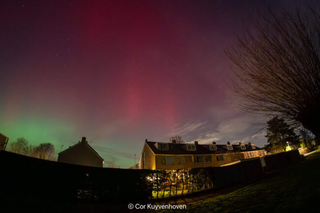 Noorderlicht boven een huis in de nacht.